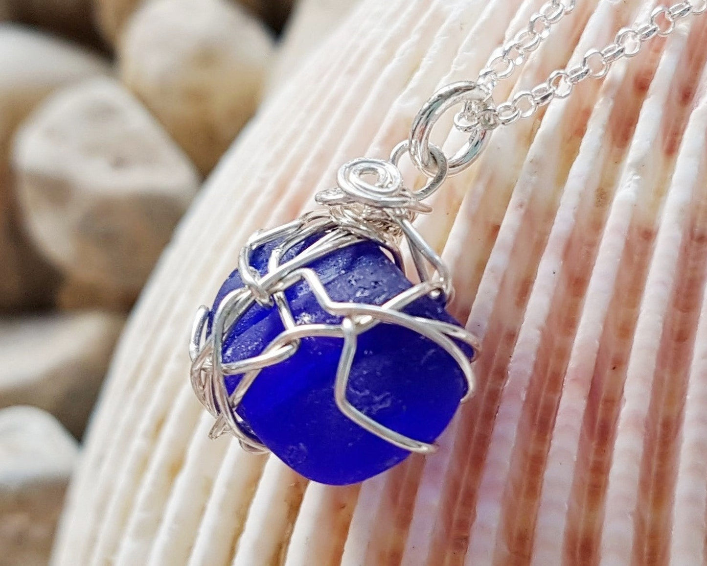 Sapphire Blue Passion Beach Glass Pendant Necklace, Sterling Silver wire wrapped blue beach glass pendant on rolo style chain. Displayed on shell