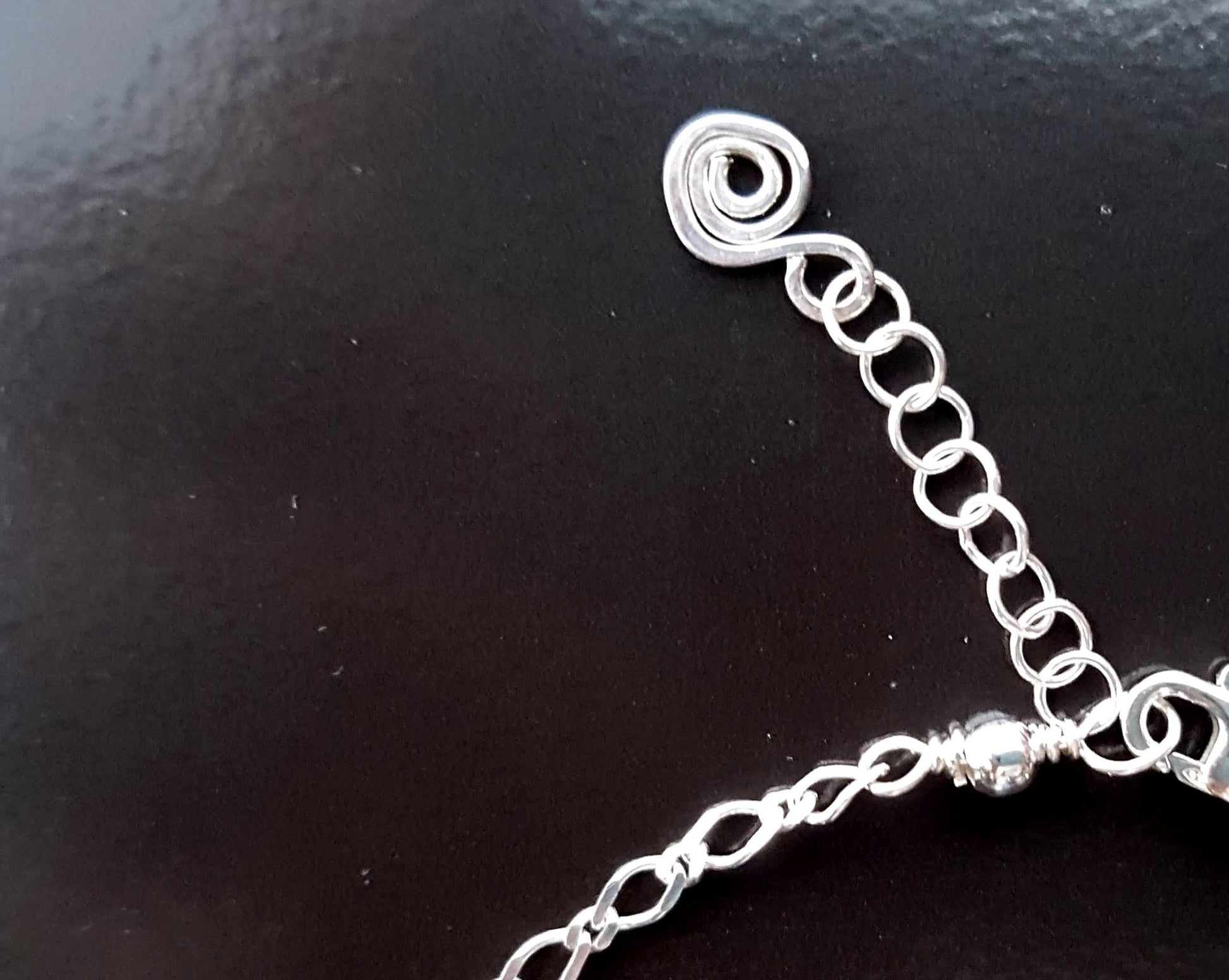 Back of Anklet with extension chain and lobster claw as well as an Eternity Coil pendant dangling on the end