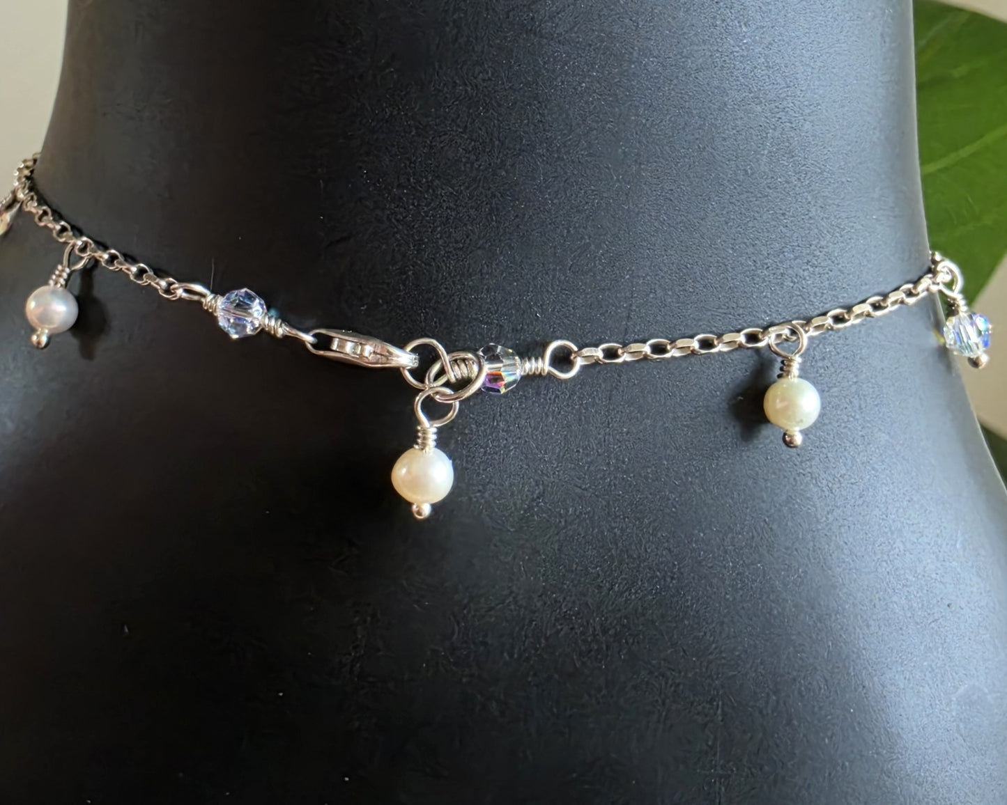 Silver Anklet Ankle Bracelet with small white Freshwater Cultured Pearls and Crystal Dangles from on chain with lobster claw clasp displayed on black ankle