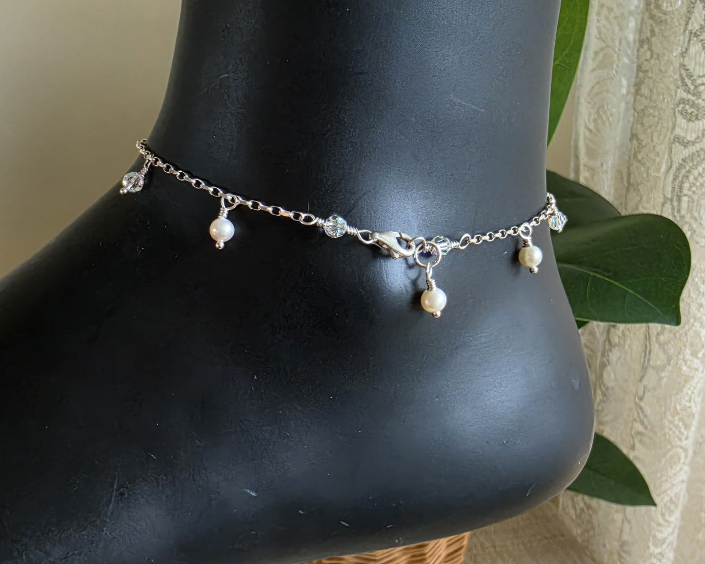 Silver Anklet Ankle Bracelet with small white Freshwater Cultured Pearls and Crystal Dangles from on chain with lobster claw clasp displayed on black ankle