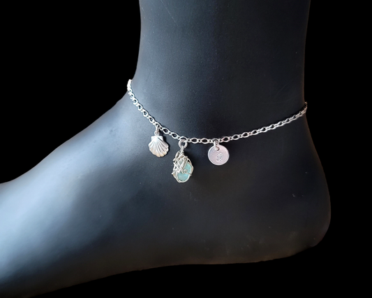 Silver Anklet with Fancy Chain and dangling Shell, Aqua Blue Beach Glass wire wrapped pendant and round disk shaped initial pendant on black background 