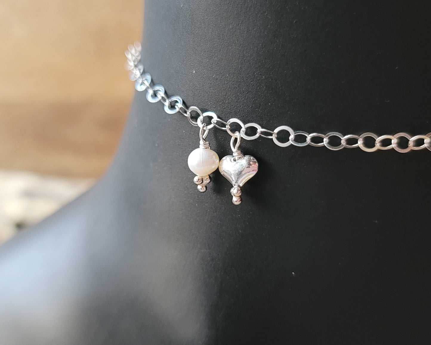 Silver Chain Anklet Ankle Bracelet with a small dangling heart and pearl on black foot