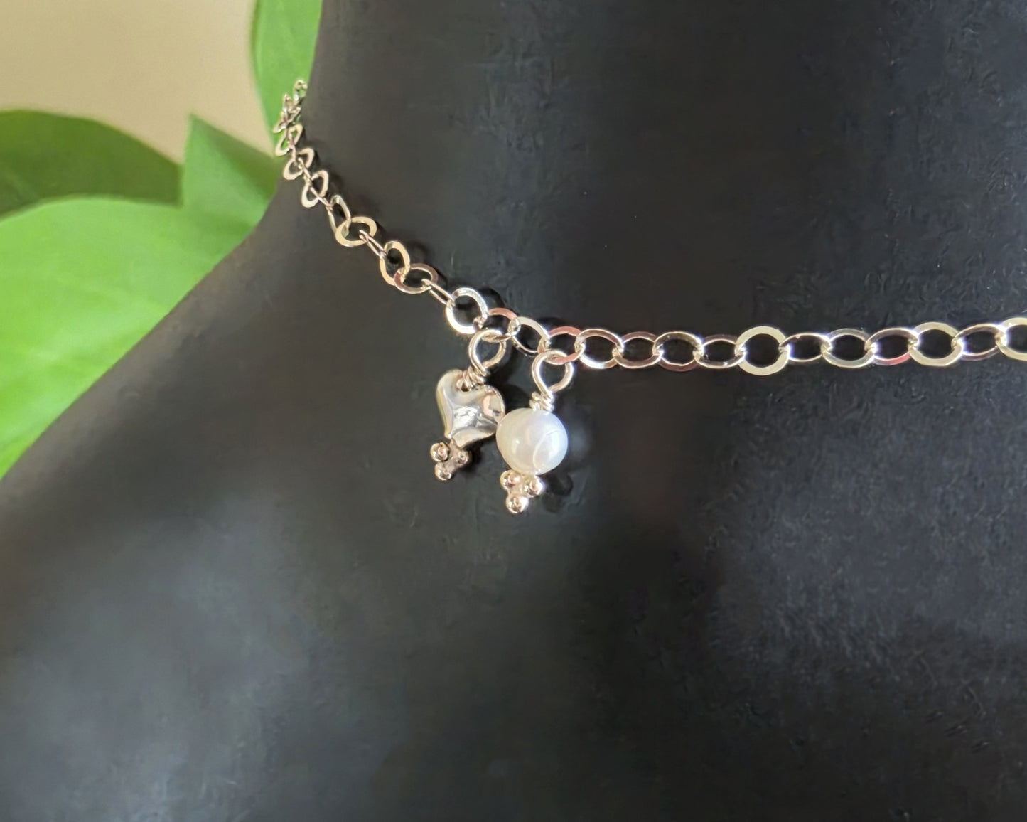 Silver Chain Anklet Ankle Bracelet with a small dangling heart and pearl on black foot