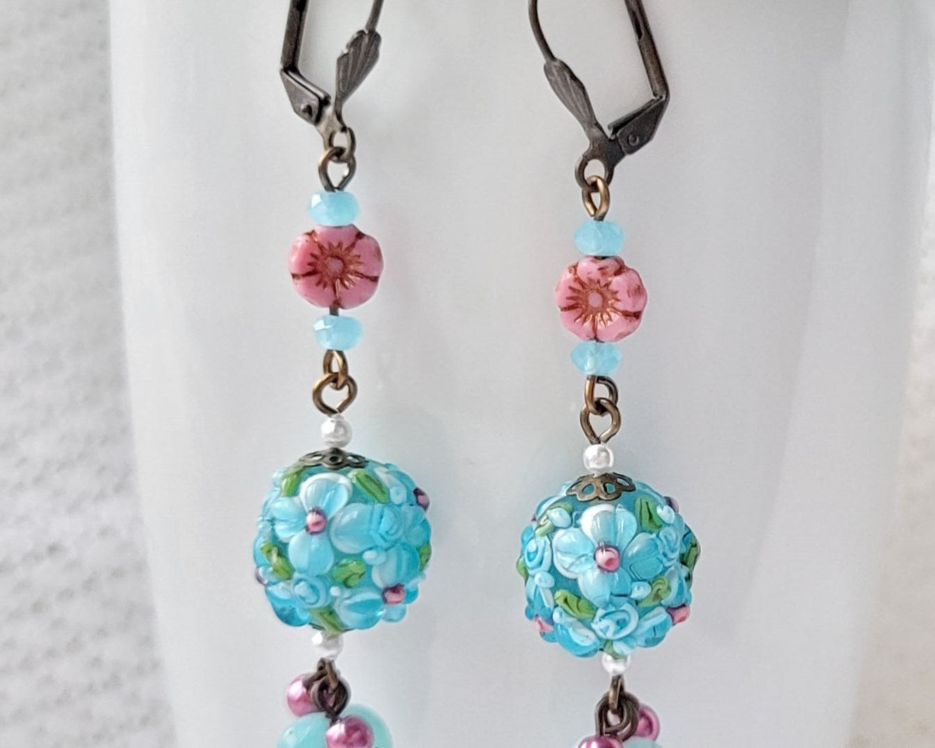 Long Aqua Pink Floral Dangle Earrings displayed on white