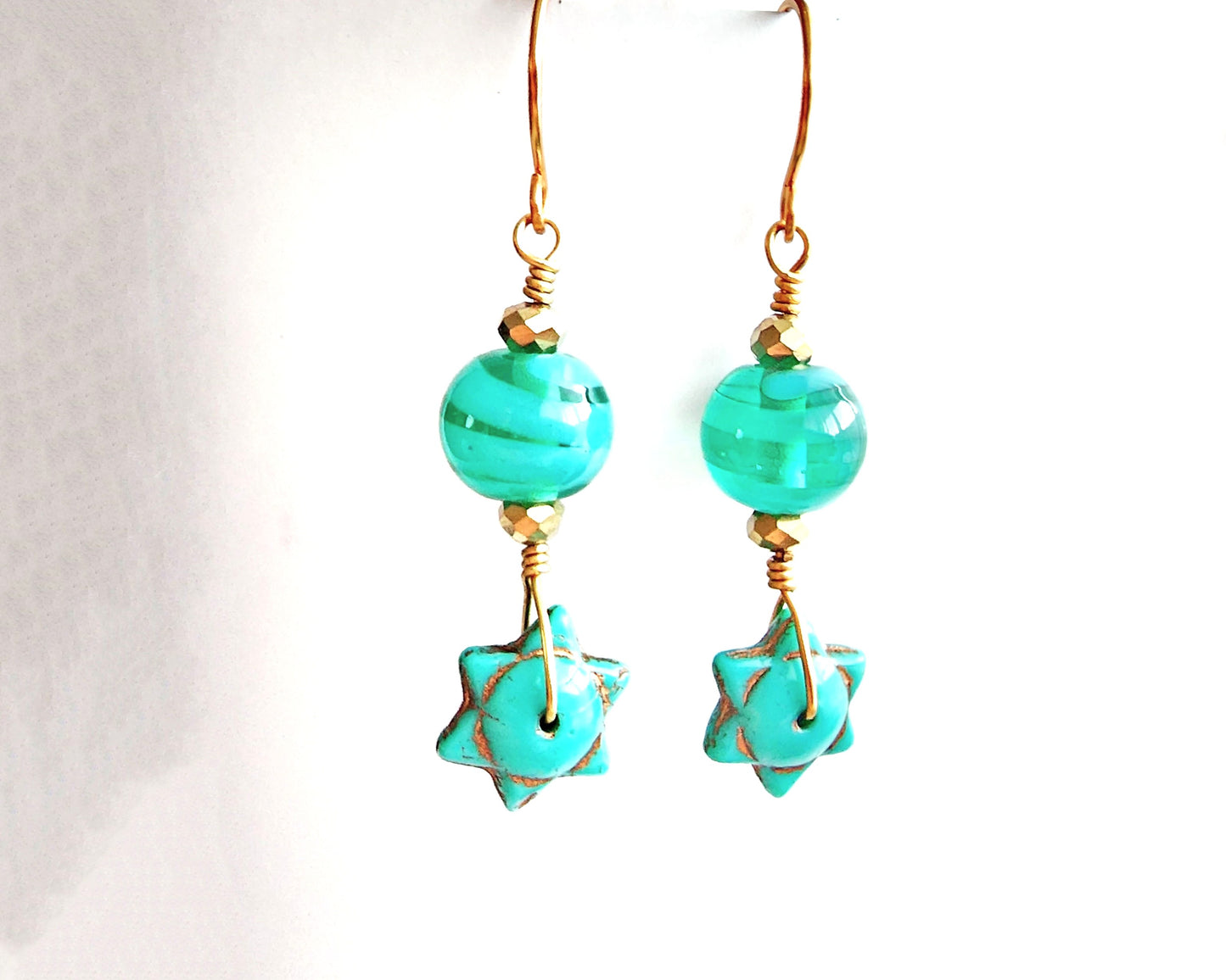 Handmade Turquoise Star beaded Wire Wrapped long dangle earring with gold wire and sparkly gold beads on french hooks with white background 