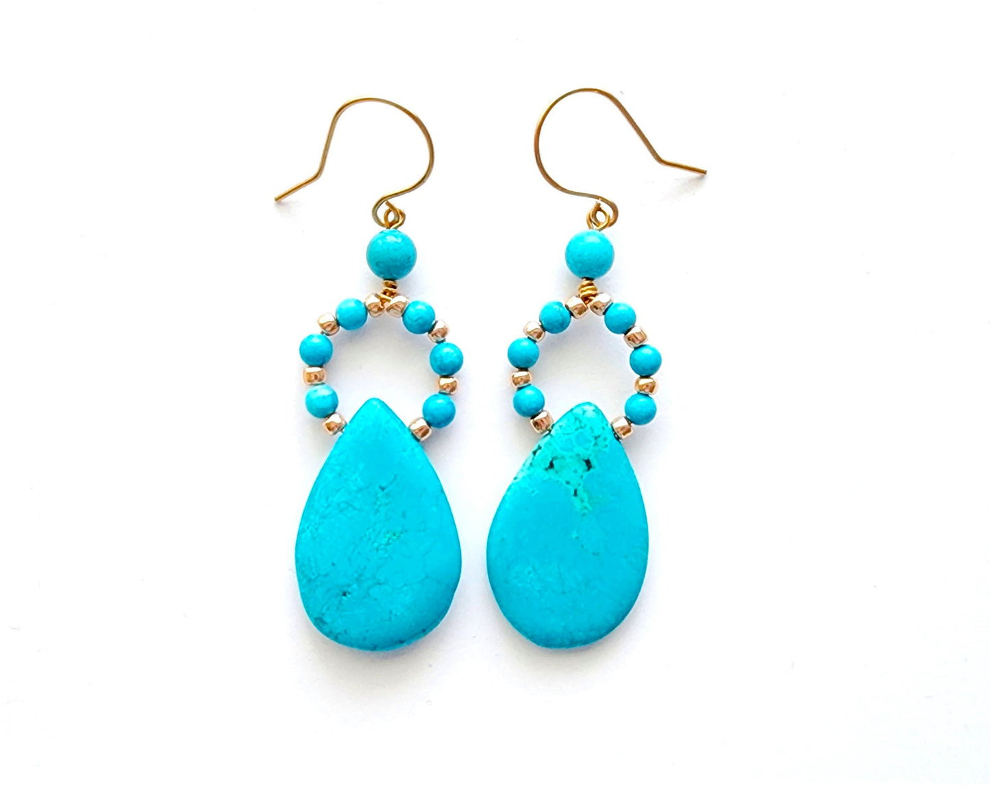Long turquoise blue drop shape hoop dangle earring with large drop shape stones and gold wire and french earring hooks on white background