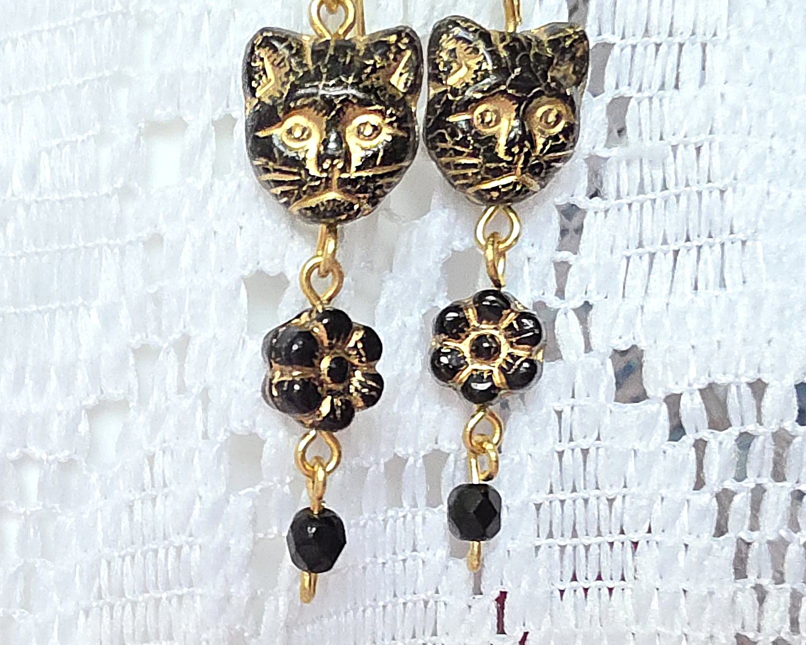 Long Beaded Black Cat Earrings with Gold detail and Brass french hooks on lace background 