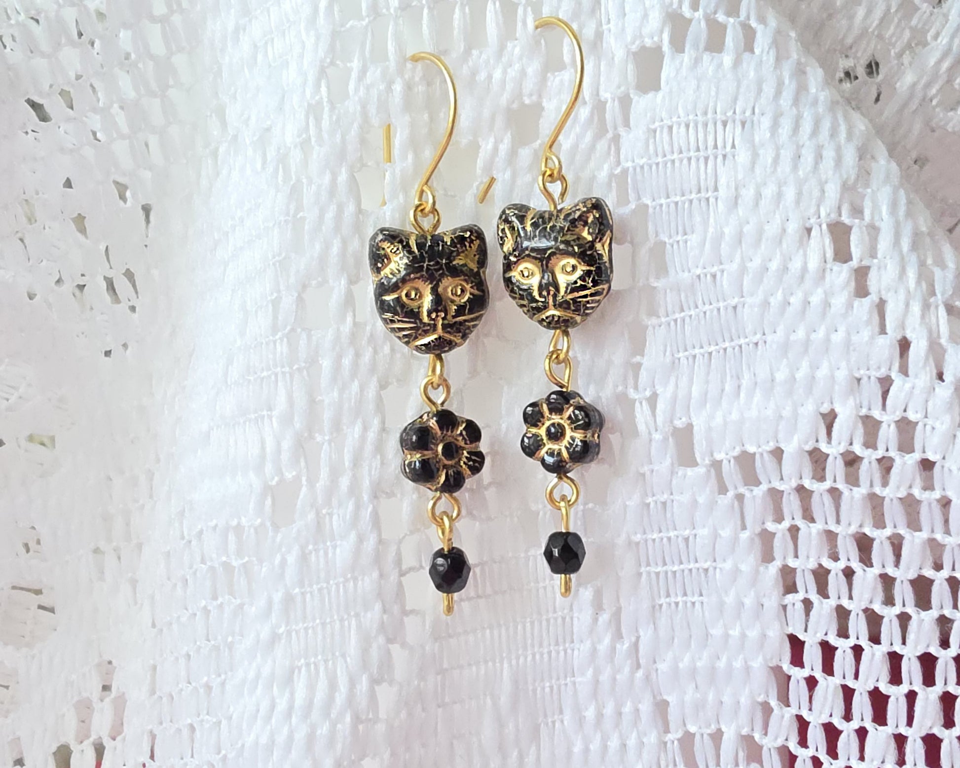 Long Beaded Black Cat Earrings with Gold detail and Brass french hooks on lace background 