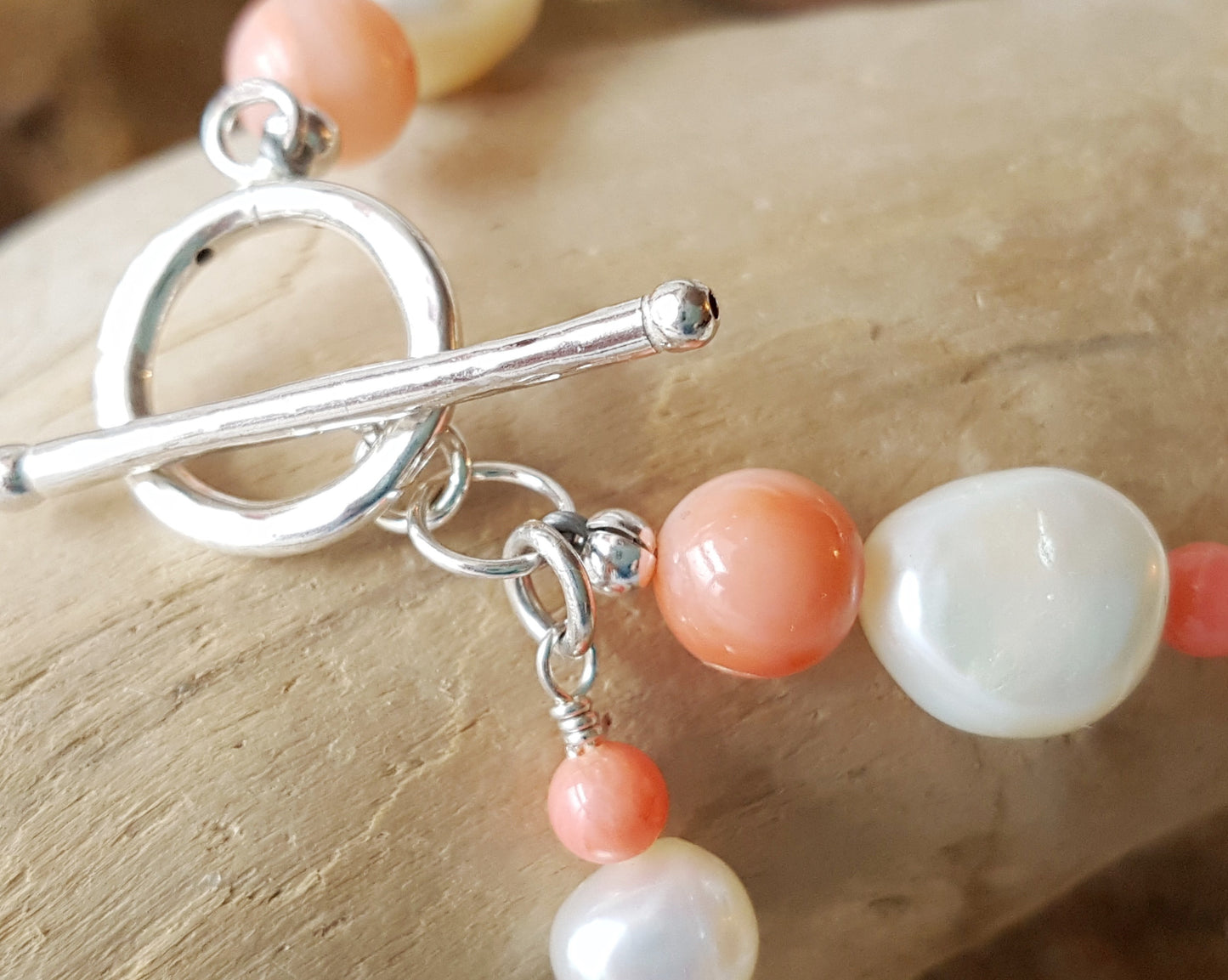 Angle Skin Coral, Mother of Pearl, Freshwater Cultured Pearl Beaded Bracelet. Pale orange Coral, white Mother of Pearl, white Pearls. Round Toggle clasp. Sterling Silver