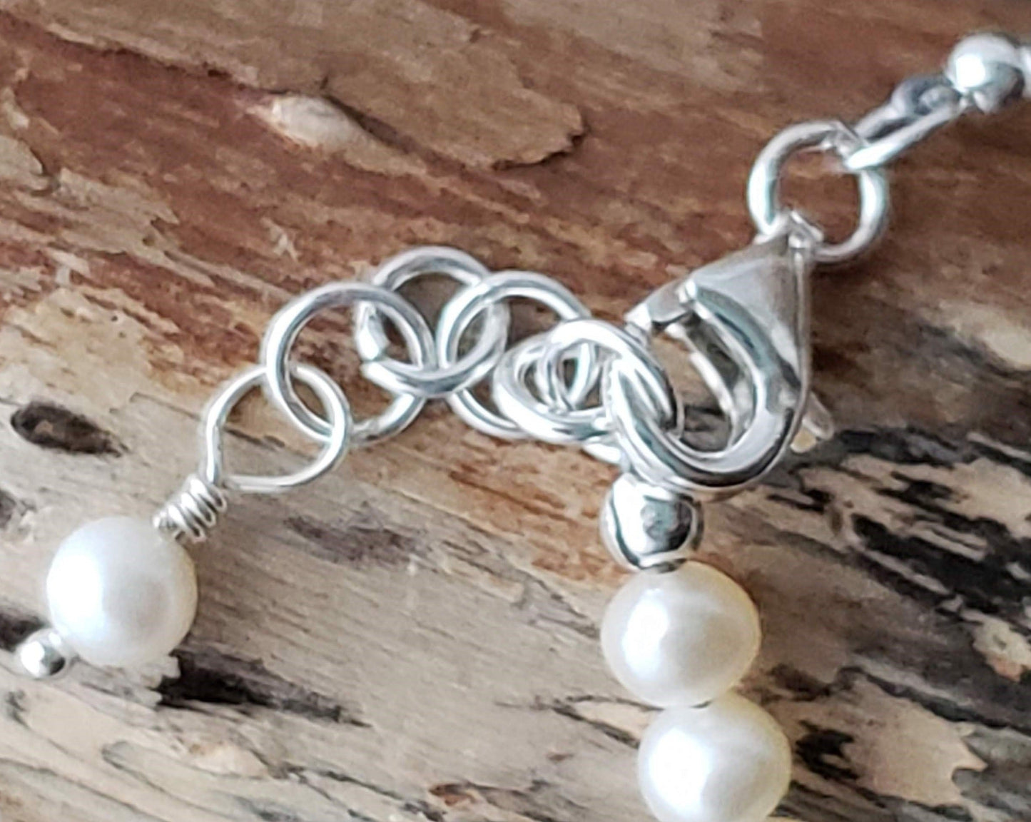 Lobster Claw Clasp and Extension Rings on Pearl Bracelet on Wood