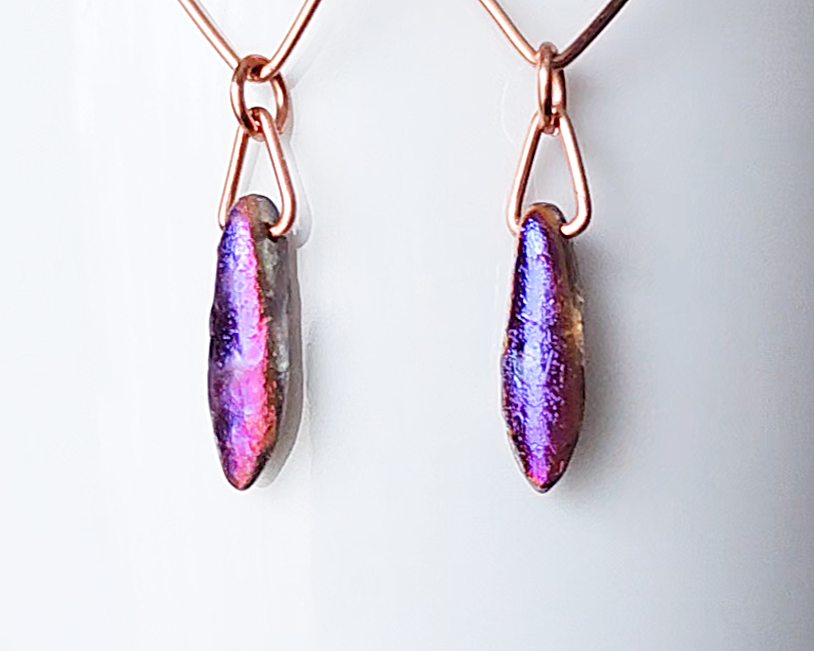 dagger shaped Iridescent Purple Blue pendants dangling on the base displayed on white background 