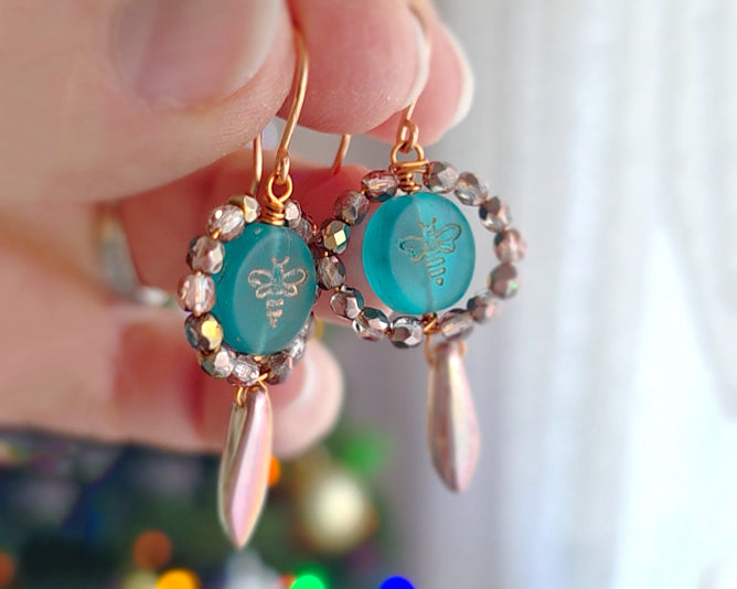 A pair of handmade turquoise aqua blue glass bee earrings with gold detail, gold and copper beads and wire on french earrings hooks