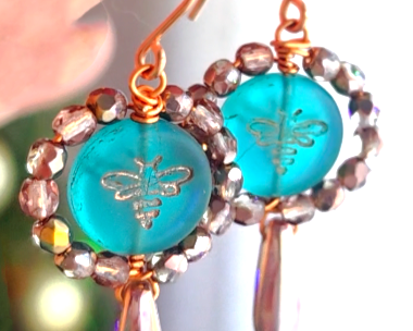 A pair of handmade turquoise aqua blue glass bee earrings with gold detail, gold and copper beads and wire on french earrings hooks