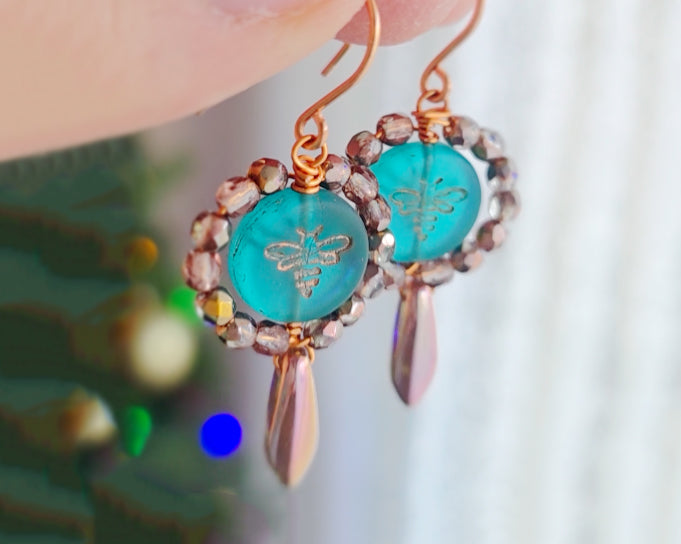 A pair of handmade turquoise aqua blue glass bee earrings with gold detail, gold and copper beads and wire on french earrings hooks