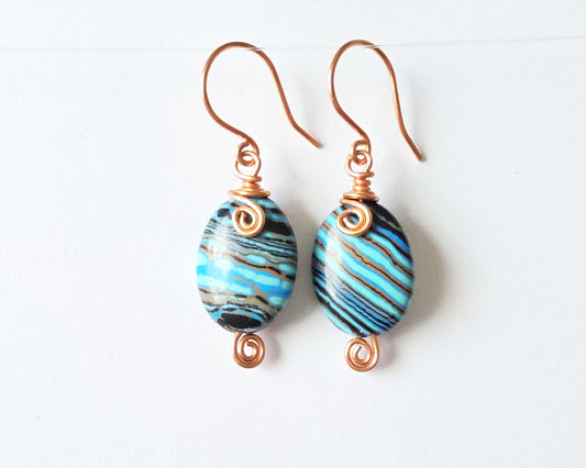 Celtic style marbled multi color copper earrings with coils and french earring hooks with white background 