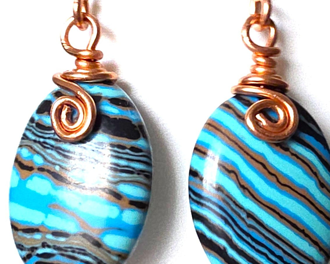 Celtic style marbled multi color copper earrings with coils and french earring hooks with white background 