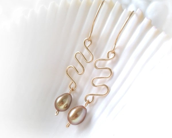Long Gold Swirling, Wavy Design Earrings and drop shape gold Freshwater Cultured Pearls dangling from French style earring hooks, on white Background  