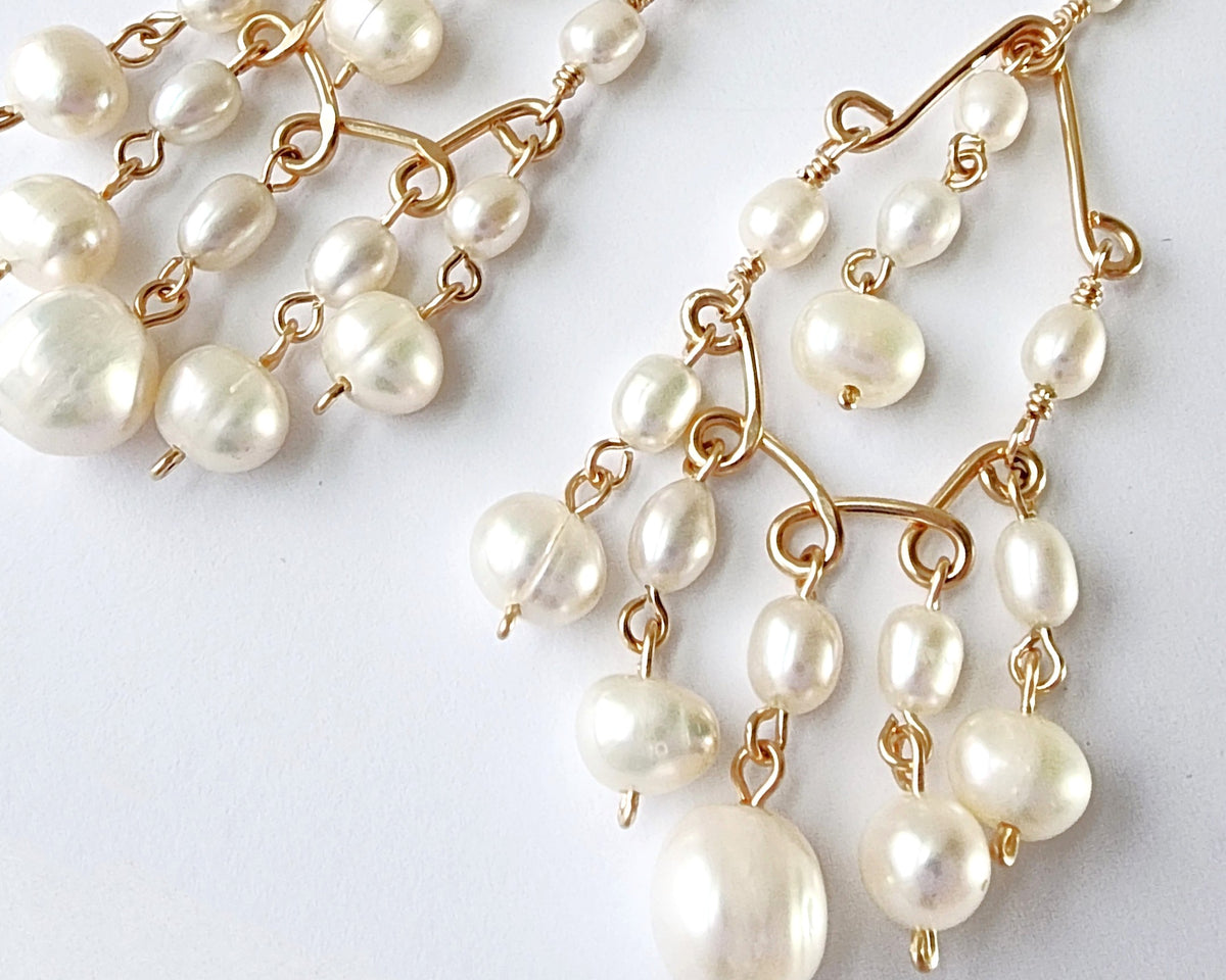 A pair of Long bohemian style elaborate pearl chandelier earrings, 14k Gold Filled and white Freshwater Cultured Pearls on white background 