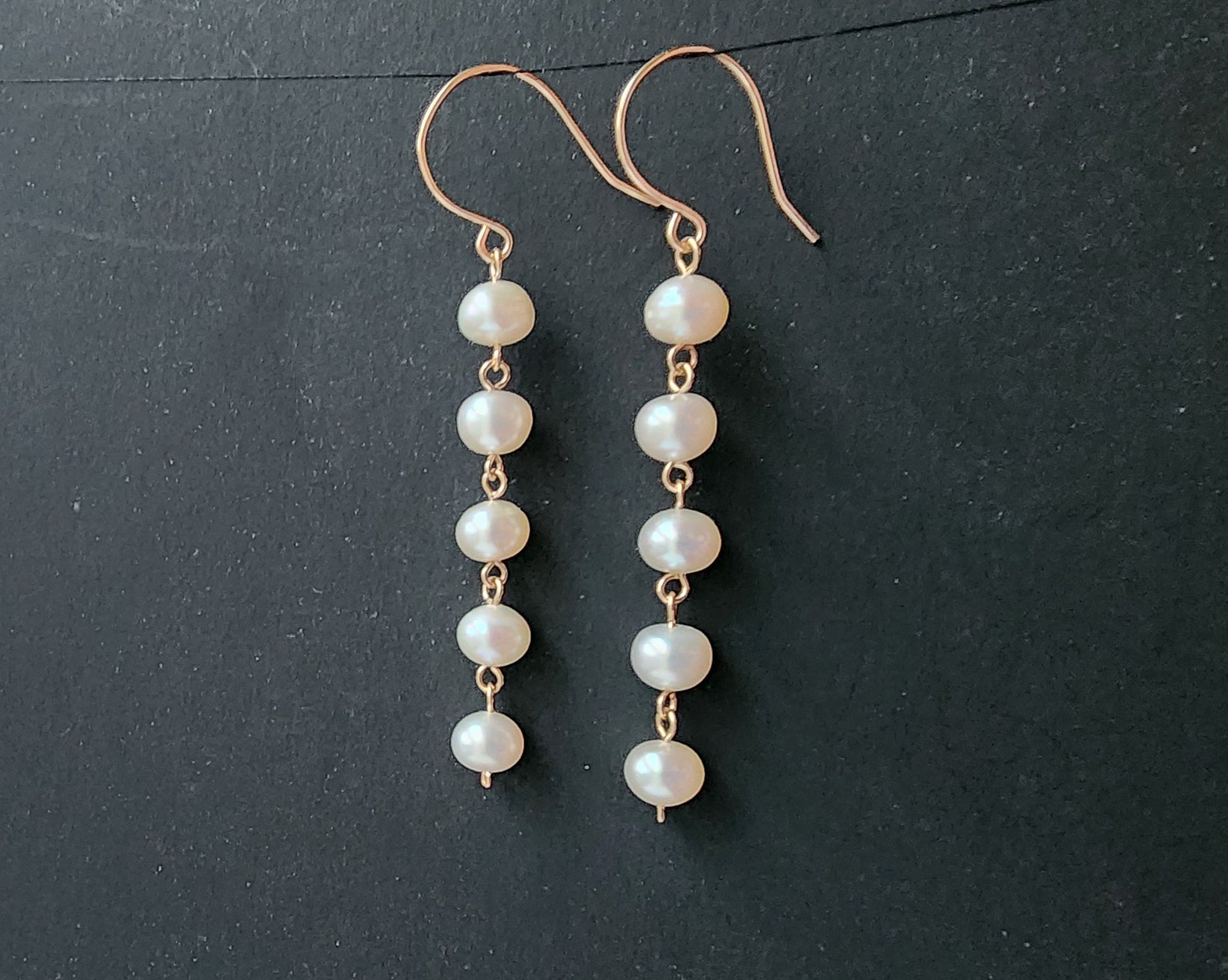 Long white pearl Dangle earrings with five round  Freshwater Cultured Pearls and 14k gold filled metal, dangling from French style earring wires. 