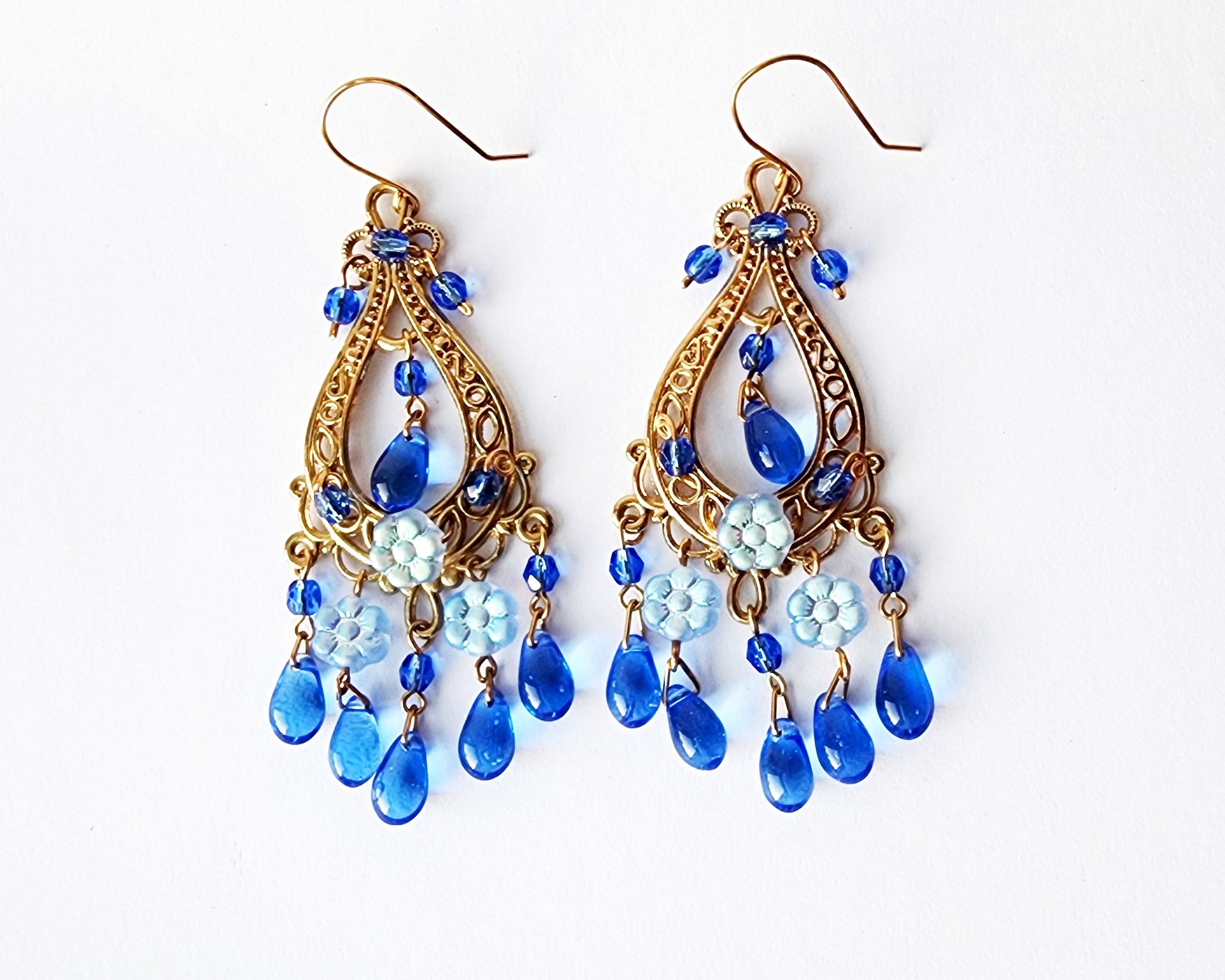 Long Eco Blue Floral Chandelier Earrings, large gold design with sapphire blue glass dangles and lighter blue flowers, on French style earrings wires. 