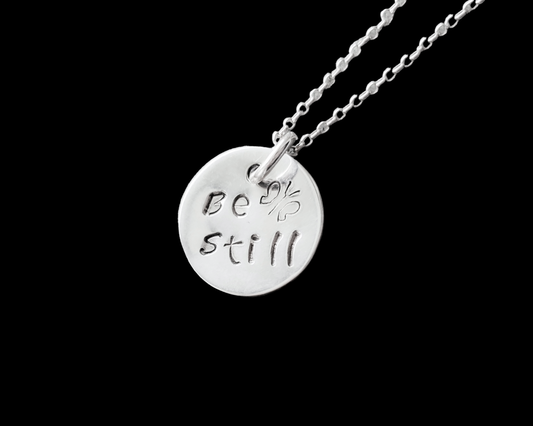 Sterling Silver Pendant that says Be Still and has a Butterfly, the Pendant is round and dangle on a rolo style chain.