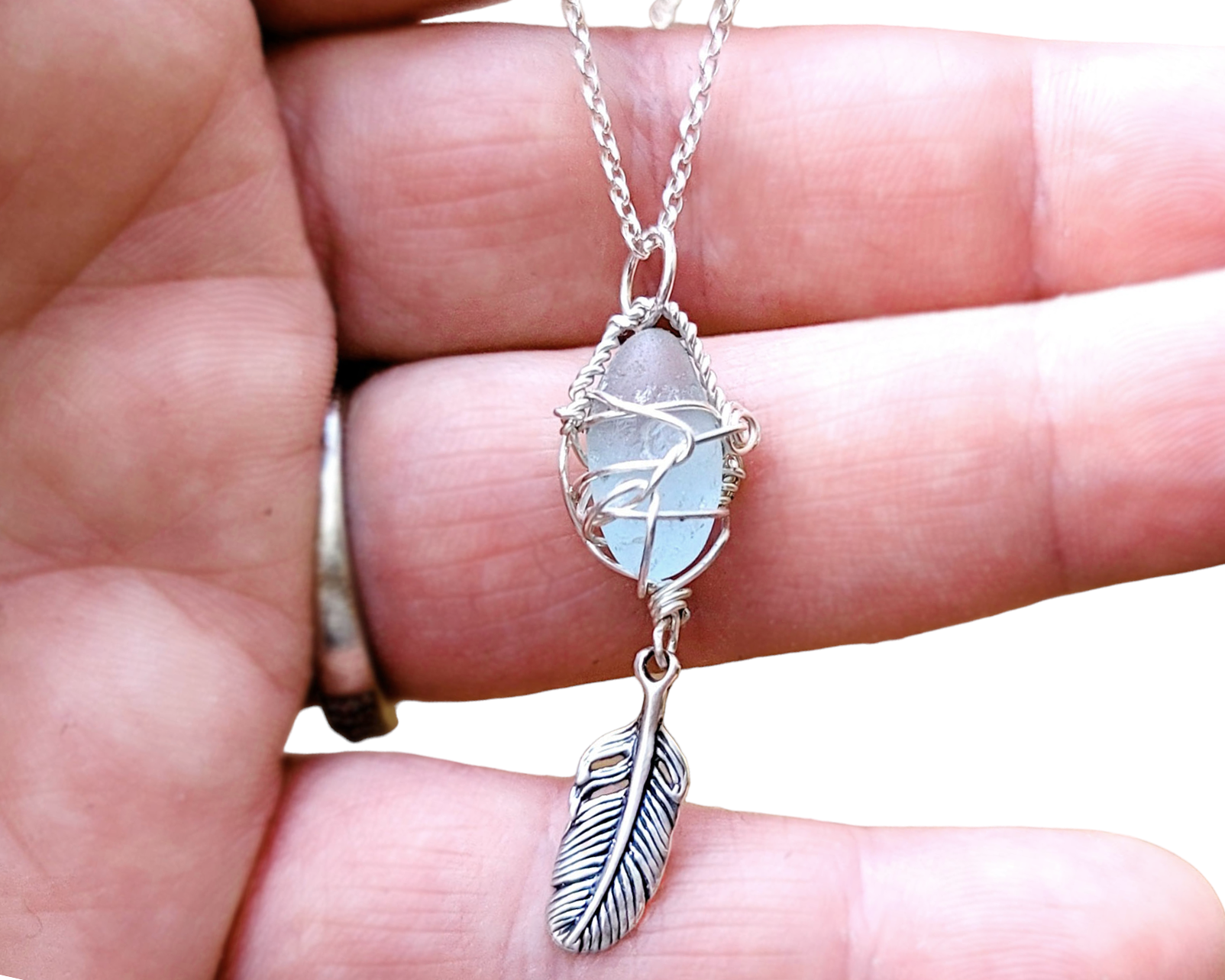 Sterling Silver, Aqua blue Beach Glass (Freshwater Sea Glass) Pendant, Wire Wrapped design with dangling Feather. The pendant dangles in rolo link chain.  