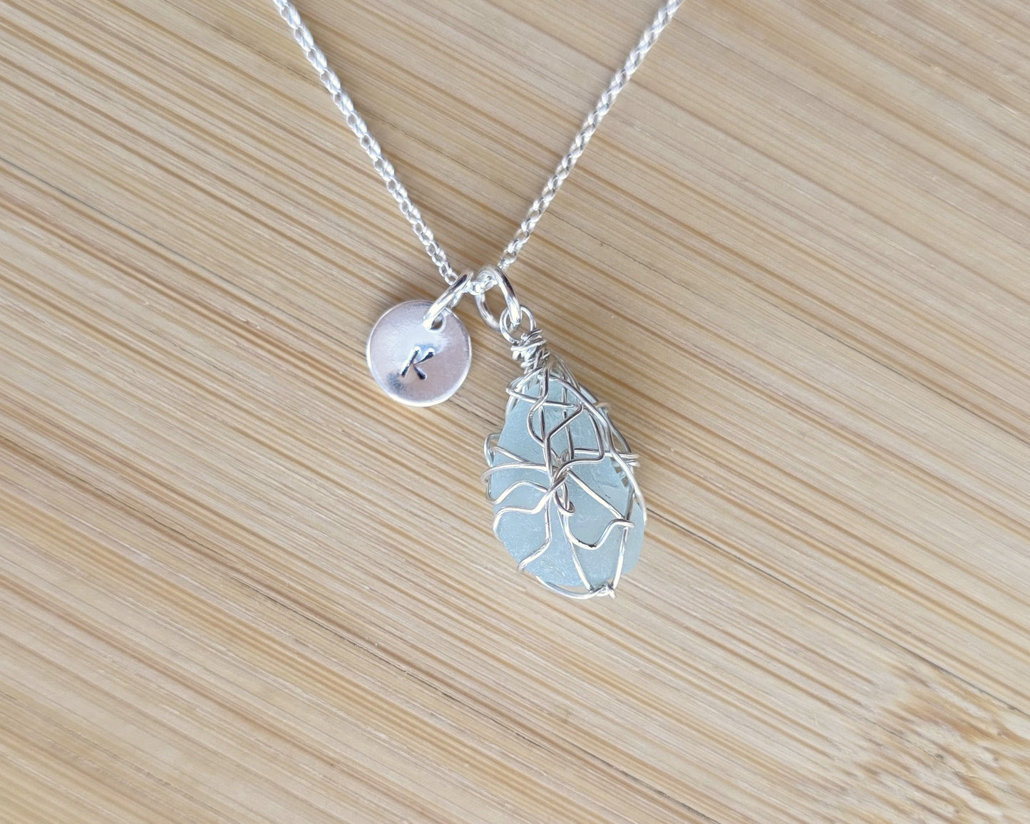 Aqua Blue Sea Glass, Freshwater Sea Glass Wire Wrapped Pendant Necklace with Initial Pendant on Sterling Silver Rolo Chain on wood background