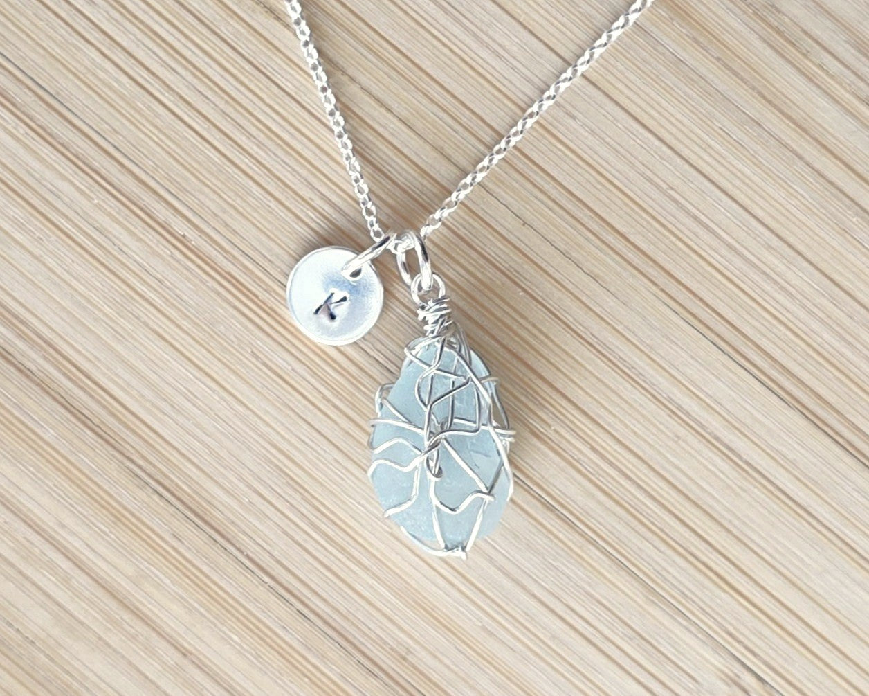 Aqua Blue Sea Glass, Freshwater Sea Glass Wire Wrapped Pendant Necklace with Initial Pendant on Sterling Silver Rolo Chain on Wood background 