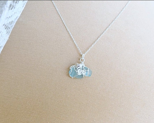 Aqua blue Sea Glass pendant with a Heart & wire wrapped design on Rolo Chain with beige background 