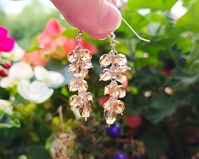 Long sparkly cluster earrings with Champagne Aurora Borealis beads on Sterling Silver with French style earring hooks with Flower garden background