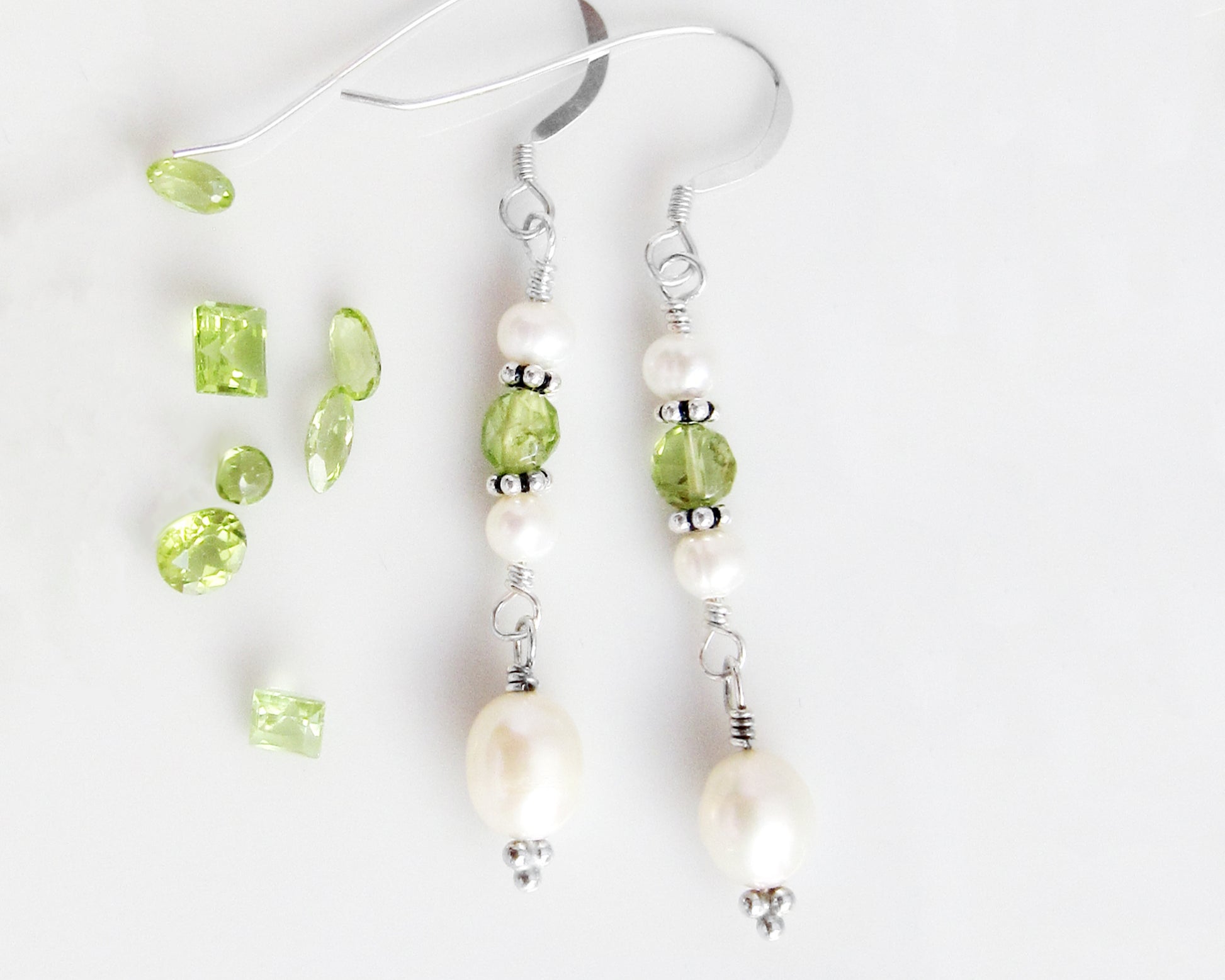 Long Peridot & Freshwater Cultured Pearl Dangle Earrings with Sterling Silver earring hooks displayed on white background with green gemstones 