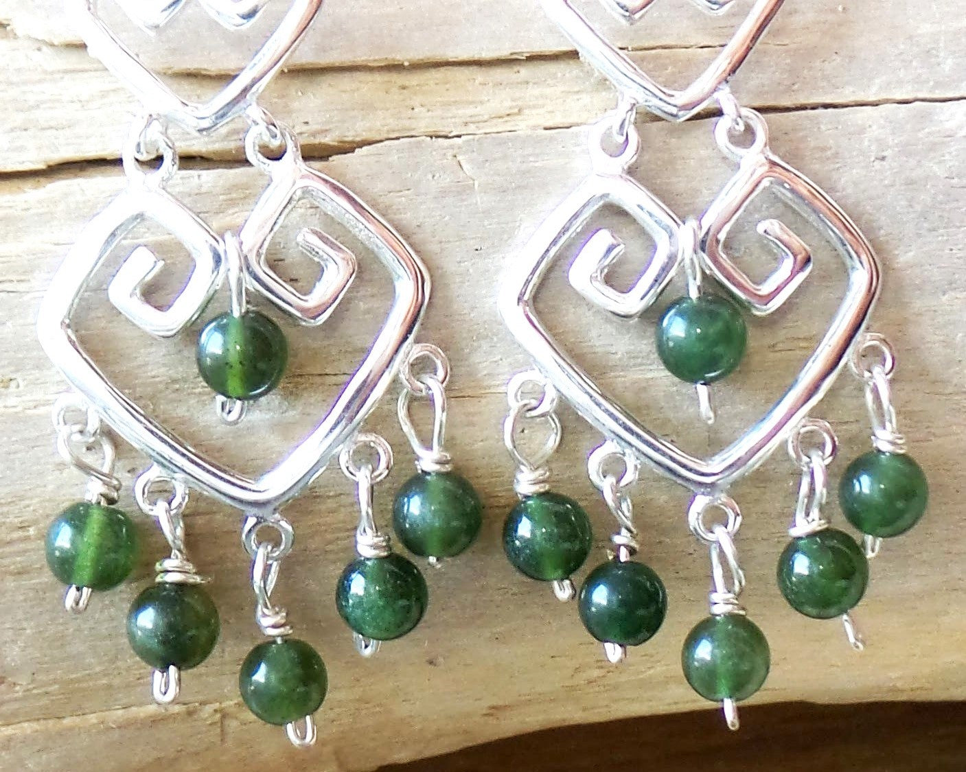 Long Grecian Style Jade Chandelier Earrings made with solid Sterling Silver and Green Jade dangles with wood background. 