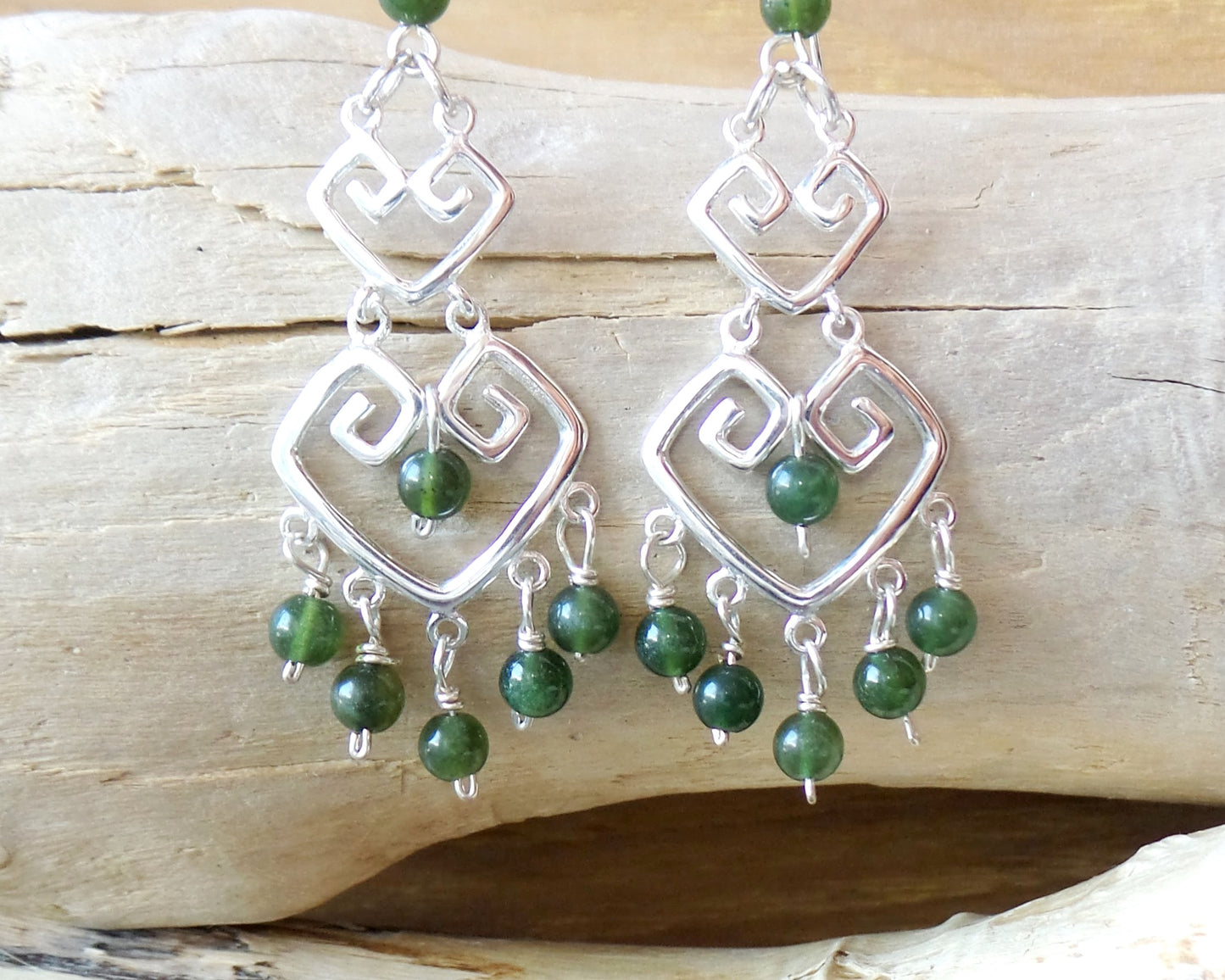 Long Grecian Style Jade Chandelier Earrings made with solid Sterling Silver and Green Jade dangles with wood background. 