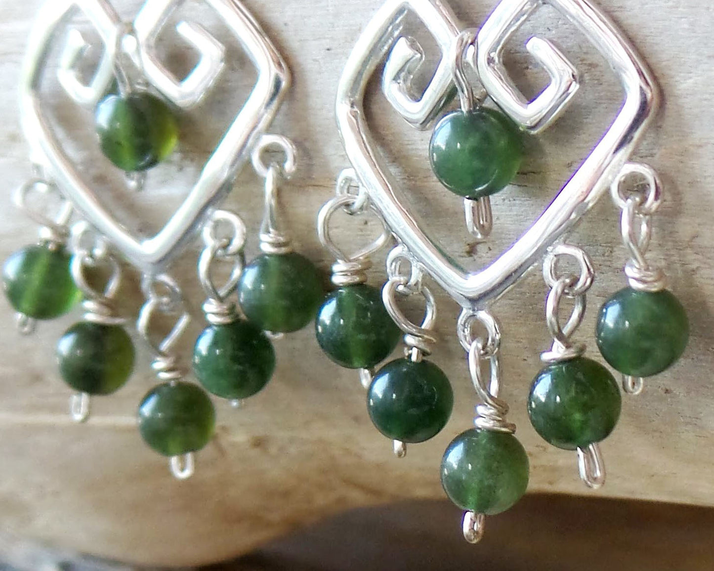 Long Grecian Style Jade Chandelier Earrings made with solid Sterling Silver and Green Jade dangles with wood background. 