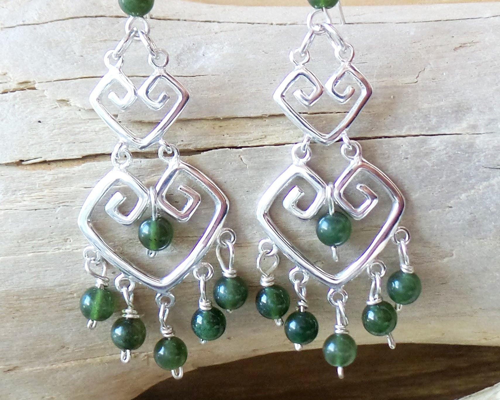 Long Grecian Style Jade Chandelier Earrings made with solid Sterling Silver and Green Jade dangles with wood background. 