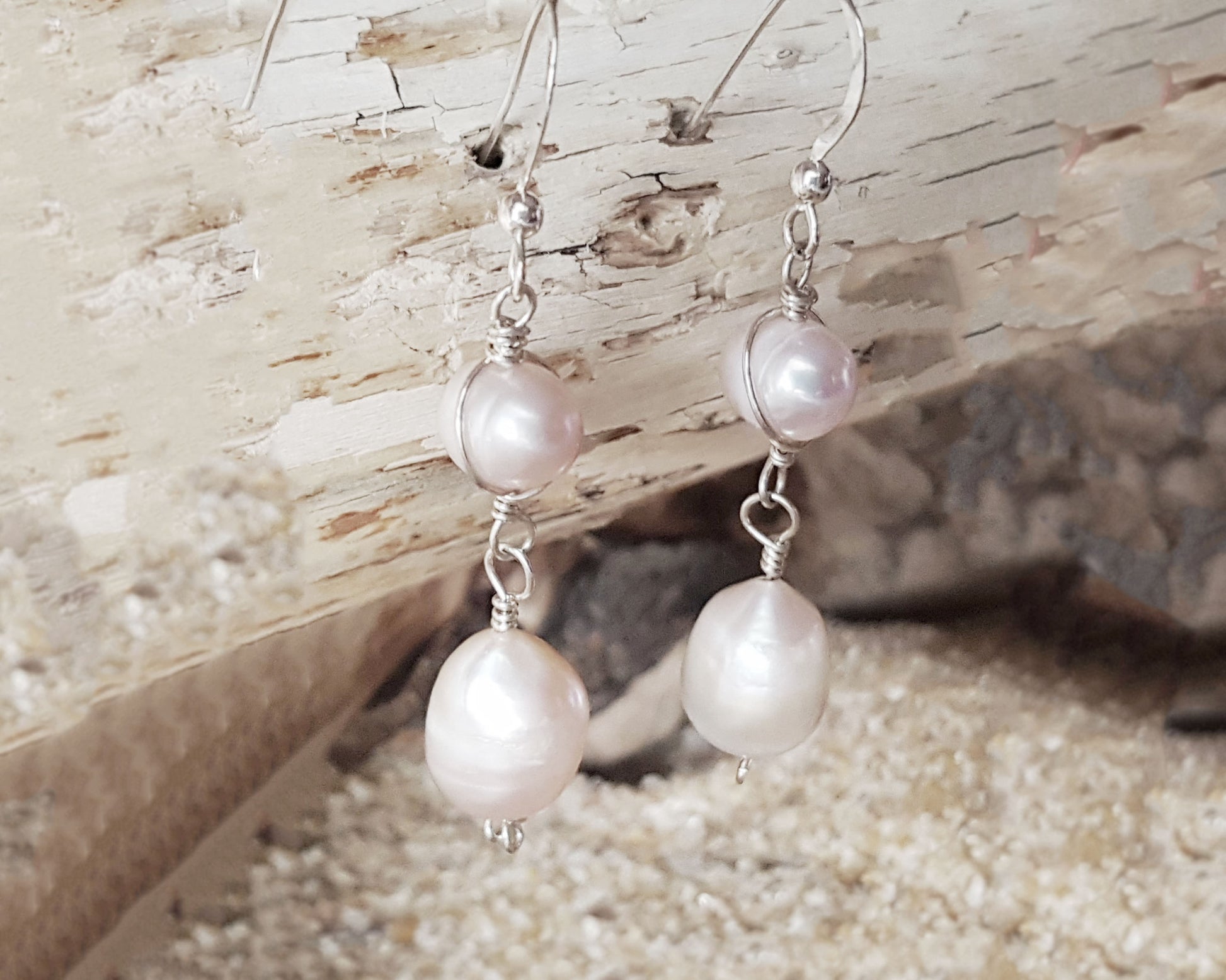 Long Celtic Pale Pink Freshwater Cultured Pearl Dangle Earrings with Sterling Silver trinity know detail on French style earring hooks on wood background 