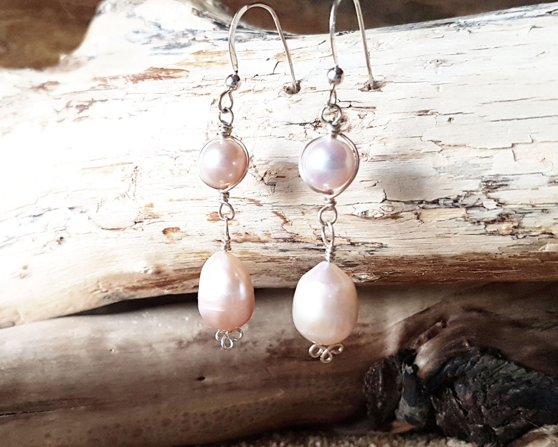 Long Celtic Pale Pink Freshwater Cultured Pearl Dangle Earrings with Sterling Silver trinity know detail on French style earring hooks on wood background 