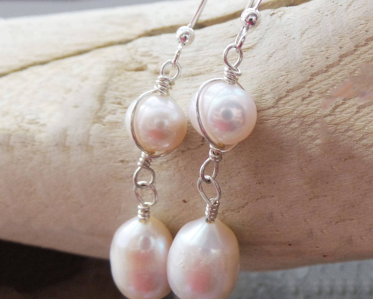 Long Celtic Pale Pink Freshwater Cultured Pearl Dangle Earrings with Sterling Silver trinity know detail on French style earring hooks on wood background 