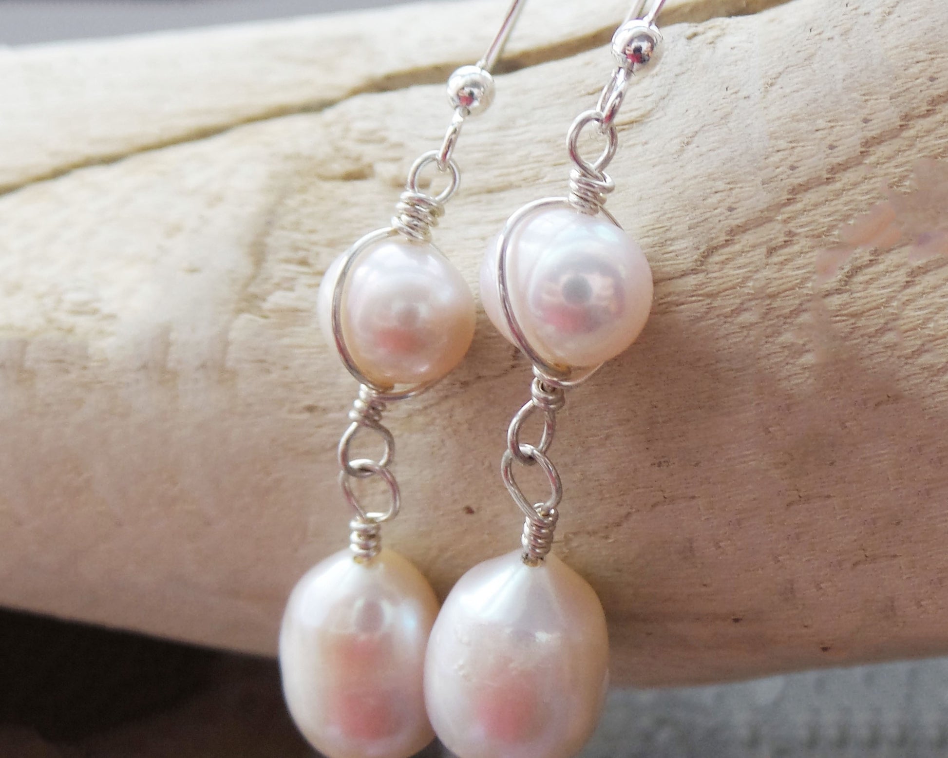 Long Celtic Pale Pink Freshwater Cultured Pearl Dangle Earrings with Sterling Silver trinity know detail on French style earring hooks on wood background 