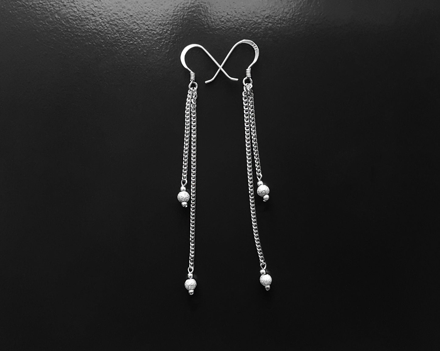 Extra Long Dangle Chain Earrings, Two long Sterling Silver chains with little sparkly balls on the base of each chain. Earrings dangle on french style earring hooks. Displayed on black background