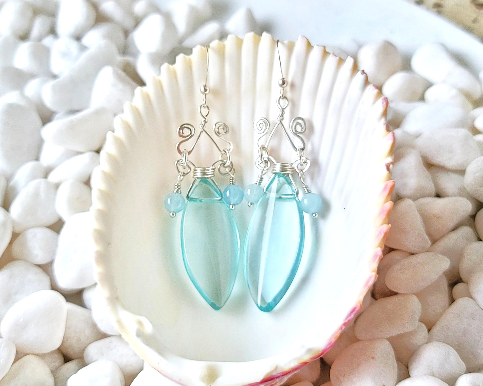 Long Art Deco Style Aquamarine Sterling Silver earrings with two Aquamarine stones & Large Aqua Blue oval shape stone with pointed ends wrapped with wire on French earring wires displayed on white background 