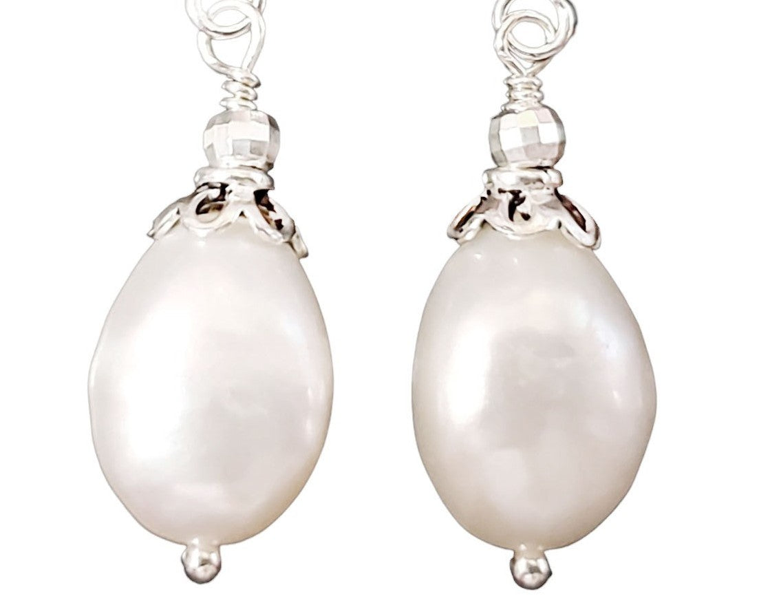 Large White Baroque Pearl Dangle Earrings with decorative silver beads and French earring hooks on white background