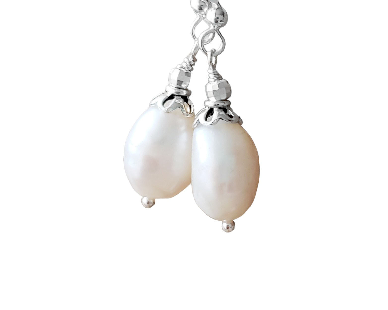 Large White Baroque Pearl Dangle Earrings with decorative silver beads and French earring hooks on white background