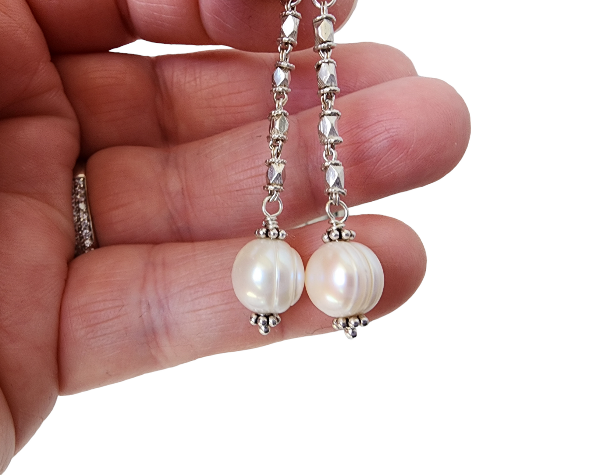 Long Art Deco Style Pearl Drop Earrings, Sterling Silver Decorative Chain with round white Freshwater Cultured Pearls displayed on hand 