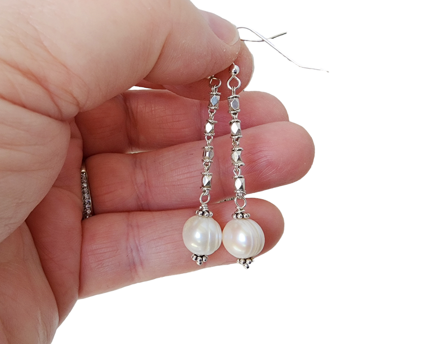 Long Art Deco Style Pearl Drop Earrings, Sterling Silver Decorative Chain with round white Freshwater Cultured Pearls displayed on hand 