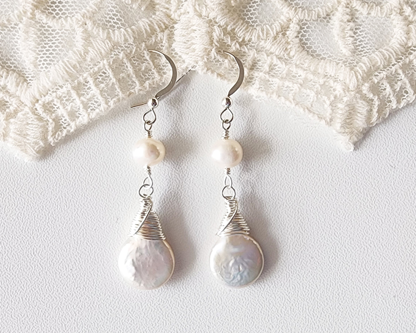 Long white Freshwater Cultured Pearl Dangle Earrings with Sterling Silver on French hooks on white background and lace