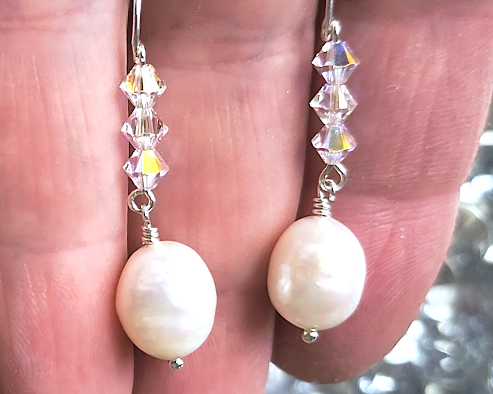 White pearl clear AB Crystal threader dangle style earrings with three clear AB crystals and large white pearl dangles on hand 