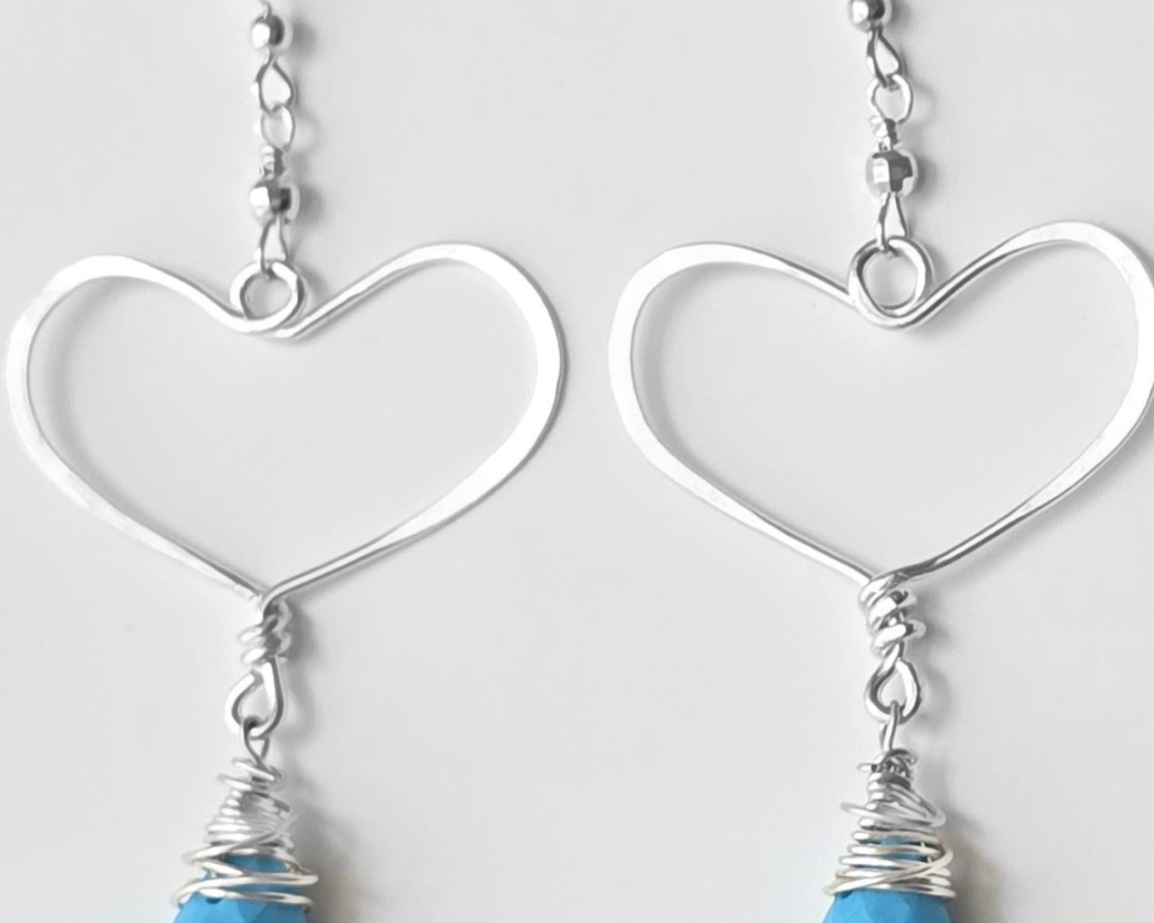 Long Sterling Silver Heart Dangle Earrings with large Hoop like Hearts and dangling Howlite drop shape stone, displayed on white background.