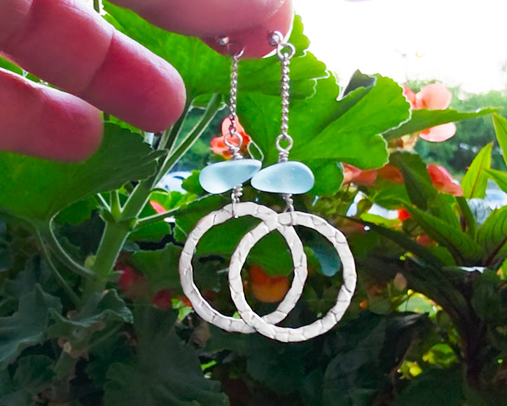 Long hoop dangle earrings on chain with aqua blue sea glass, with French hooks, displayed with flower garden