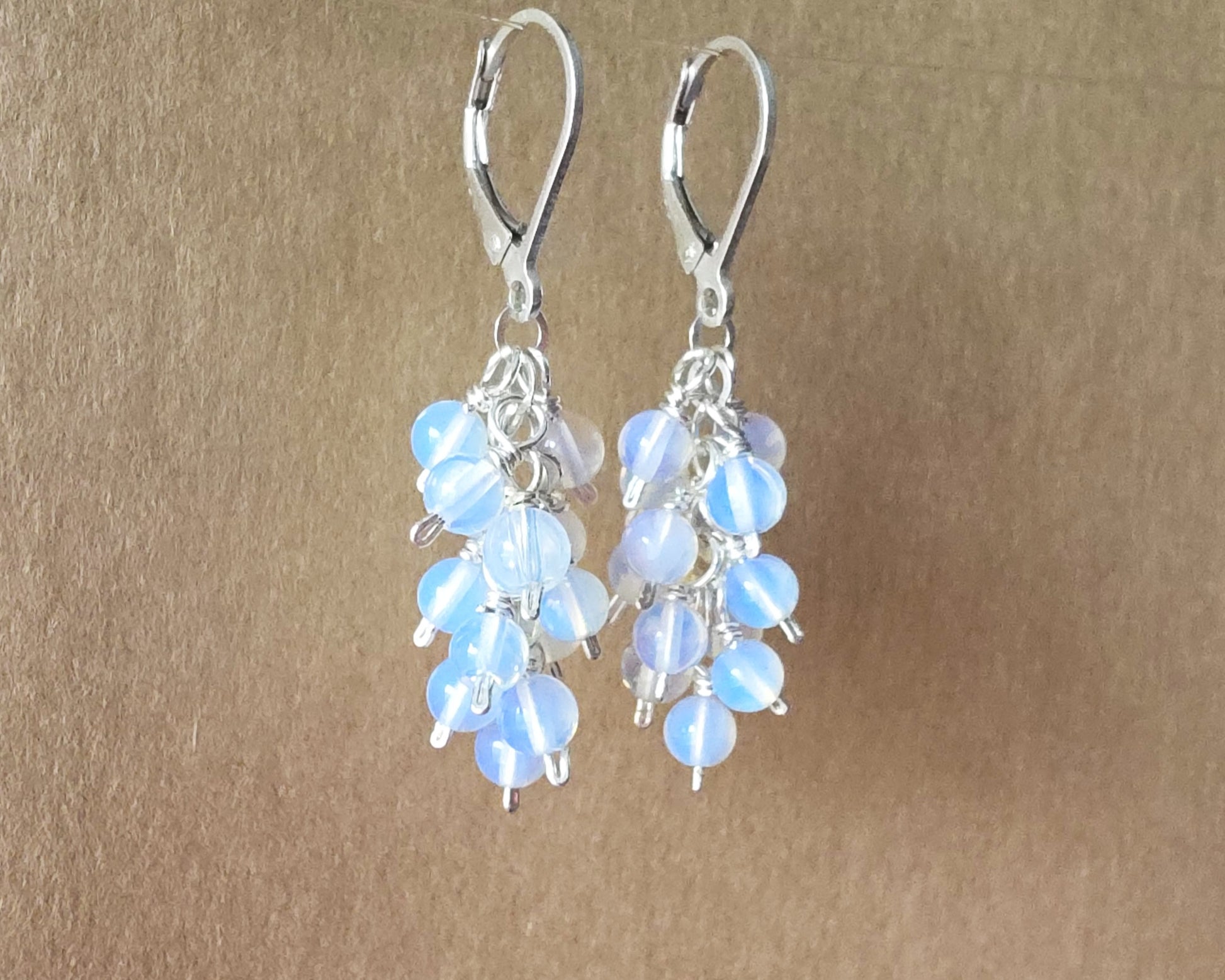 Sterling Silver Opalite Cluster earrings with blue gold stones on lever back earring hooks, with beige background 